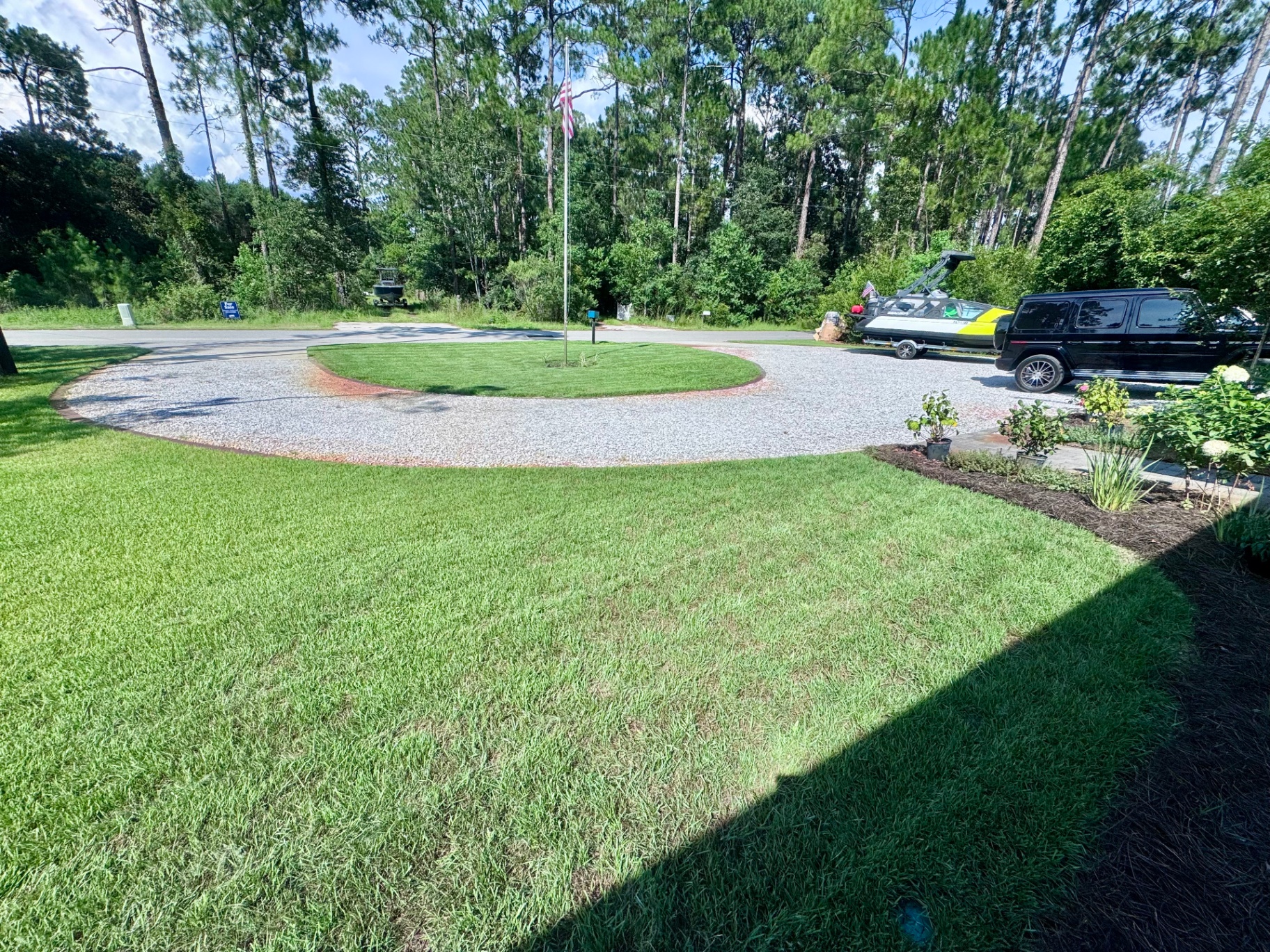 Manicured front yard with circular drive and healthy green lawn